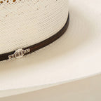 Gevlochten cowboyhoed van stro met decoratieve hoedband