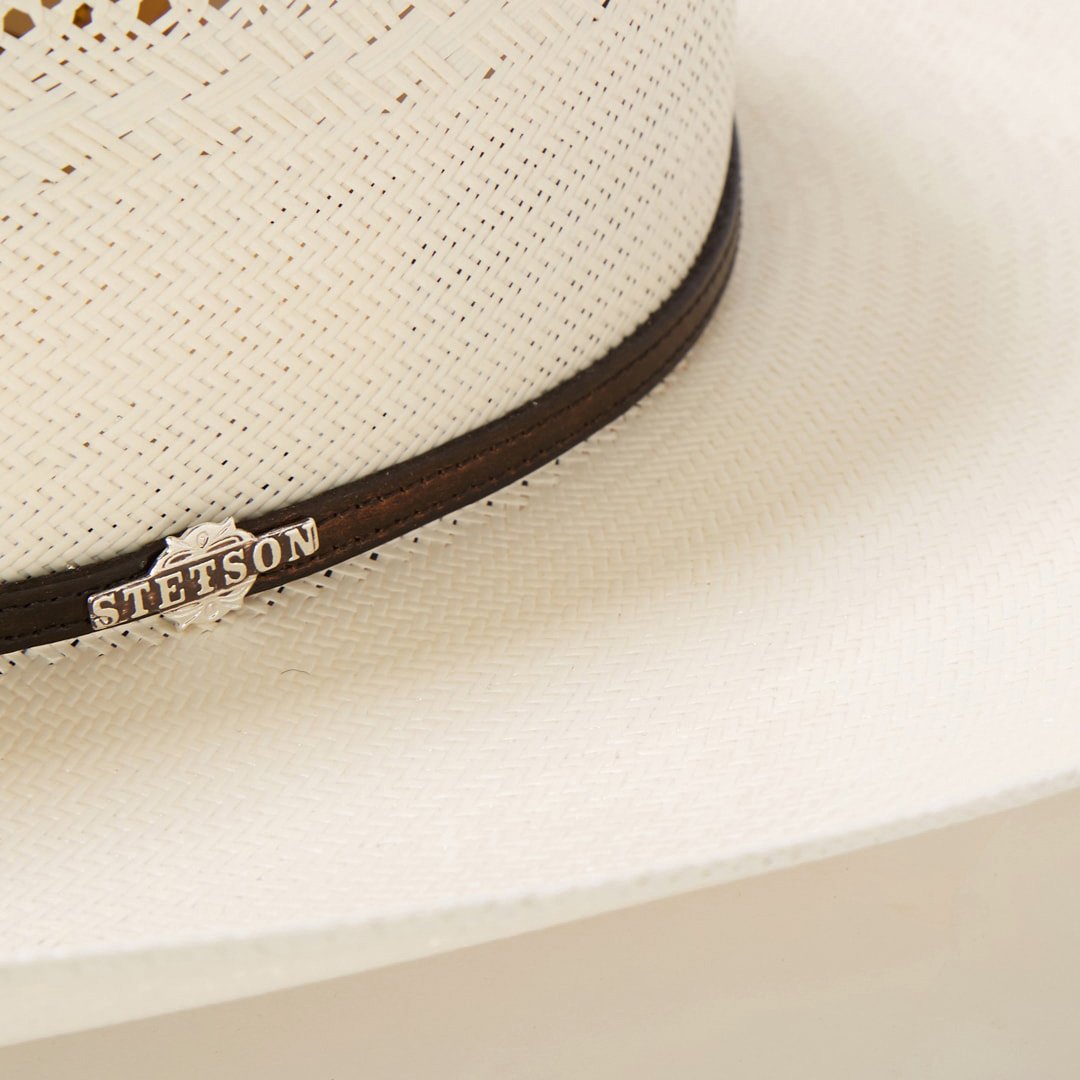 Gevlochten cowboyhoed van stro met decoratieve hoedband